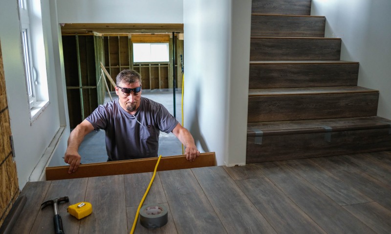 Chris installing flooring on the stairs.