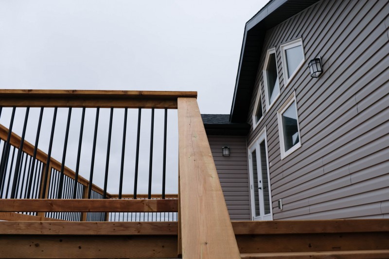 Brown treated deck with black ballusters.