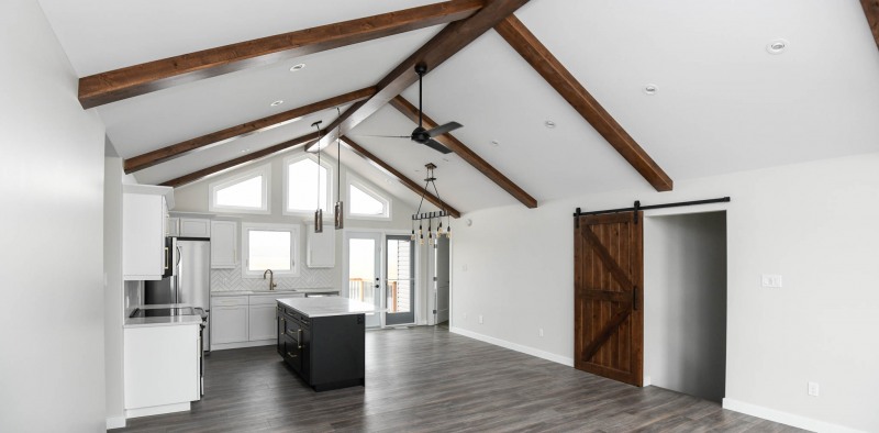 Faux beams with matching barn door in open concept floor plan.