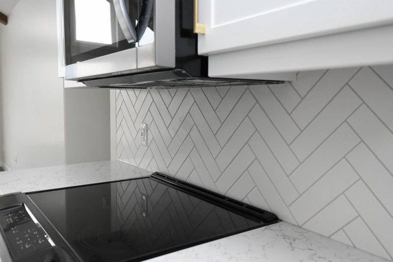 Herringbone backsplash with slide-in stove.