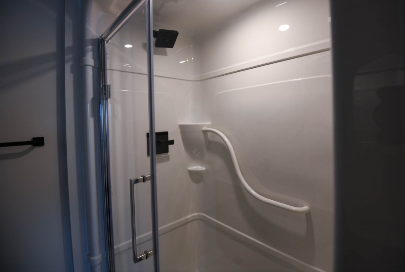 Ensuite shower with glass doors and black fixtures.